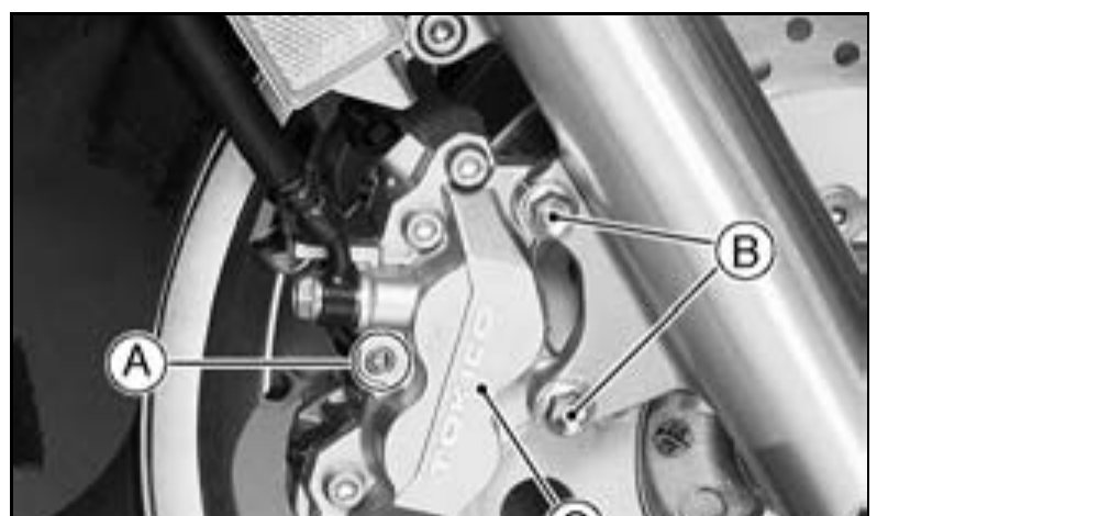 Front four-piston brake caliper mounted on the disc, with the pad pin, caliper mounting bolts and caliper body labelled.