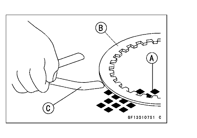 A friction/steel plate held against a surface plate with a thickness gauge checking the gap that indicates plate warp.