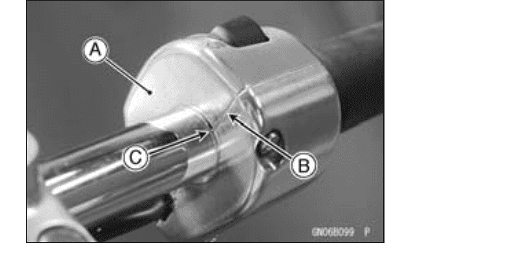 Close-up of the left handlebar end with the switch-housing mating surface set to the punched alignment mark on the bar.