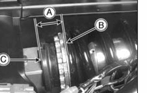 Close-up of the rear-shock lower spring seat with a measurement bracket spanning from the flange end to the spring end.